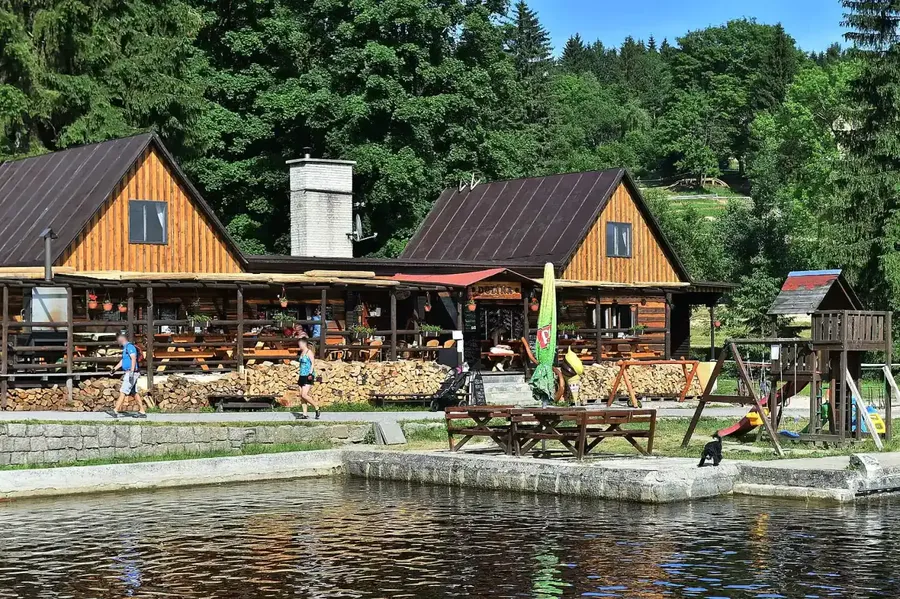 Přírodní koupaliště Dolina v Bedřichově s dřevěnou budovou restaurace